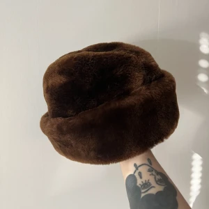 Vintage mössa - Superfin vintage pälsmössa, högst sannorligt fakepäls! Utsidan är superfin och mjuk, insidan är hel och fin. Har öronlappar och är i mycket fint skick för att vara vintage.