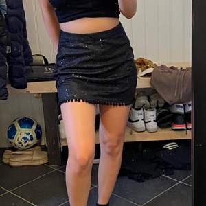 Detta är en kjol i storlek S från Mad Love, är svart glittrig och har små ”bollar” på bottnen:)