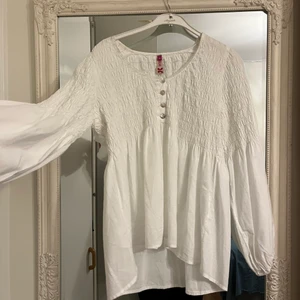 vit blus med puffärmar  - Köpt på second hand, aldrig använd, strl M men sitter även bra på S. Frakt 66 kr. Kan mötas upp i Skåne 🤍 Kan skicka bilder på hur det sitter på!