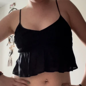 Topp - Söt och snygg svart topp i tunt och svalkande material! Kvaliteten är otroligt bra! Den har justerbara band, strechigt material över bysten (passar mig som annars har S) och volanger längst ner!💕