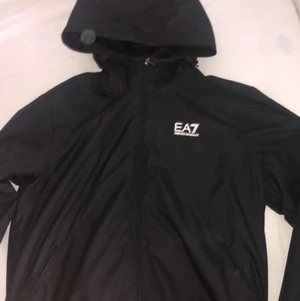 Ea7-höst jacka  - Jag säljer nu min EA7 jacka som är Aldrig använd. Den är köpt för 1000 och säljer den för 770. Jackan är rätt så skön och bekväm för den är lite pälsig/varm innuti jackan. Passa på och köp😊.b