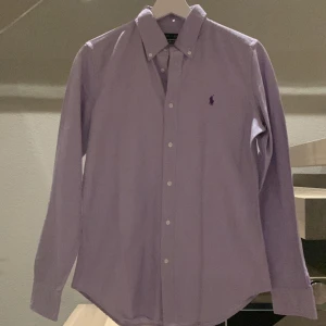 Polo Ralph Lauren skjorta  - Säljer denna coola skjortan från Ralph Lauren, den är långärmad med knappar längs handleden. Den är i en nyans av både mörkare och ljusare lila, inte använd. Köpt förra året i LA för 1200kr, Ralph Laurens egna butik. Skjortan är i modellen ”Slim Fit” Bara att skriva för fler bilder eller funderingar!❤️‍🔥