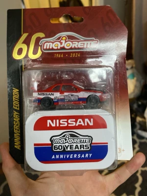 Majorette Nissan 60-årsjubileum bil - Säljer en samlarbil från Majorette, Nissan-modell i rött, vitt och blått. Det är en 60-årsjubileumsutgåva (1964-2024) och kommer i originalförpackning med en specialdesignad plåtask. Perfekt för dig som gillar bilar och samlarprylar.