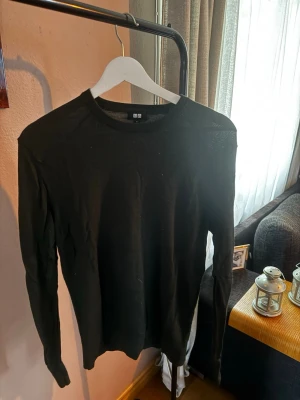 Mörkgrön stickad tröja från Uniqlo - En stilren mörkgrön stickad tröja från Uniqlo med rund halsringning och långa ärmar. Tröjan har en enkel och klassisk design som passar till det mesta. Materialet känns mjukt och bekvämt, perfekt för lager på lager under kyligare dagar.