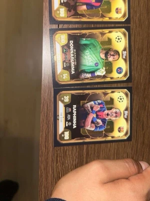 Fotbollssamlarkort Topps 100 Club - Tre exklusiva fotbollssamlarkort från Topps 100 Club-serien. Korten har guldfärgad design med spelare i matchtröjor, klubbmärken och statistik. Perfekt för dig som gillar att samla på fotbollskort och vill ha något unikt i samlingen.