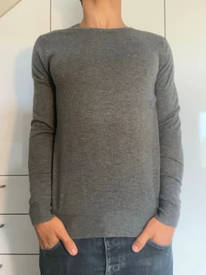 Grå stickad kashmirtröja  - Grå stickad tröja från Movesgood tillverkad i 50% Kashmir och 50% viskos. Strl S. Inga defekter. Modellen är 178 cm och väger 77 kg. Hör gärna av dig vid frågor!