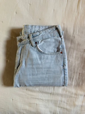 Ljusblå raka jeans - Säljer ett par ljusblå jeans med klassisk femficksmodell och raka ben. Jeansen har bälteshällor, knappgylf. Perfekta för en avslappnad och trendig look.