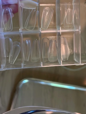Transparenta långa press-on naglar - Säljer ett set med transparenta långa press-on naglar i olika storlekar. Naglarna har en modern coffin-form och kommer i en praktisk förvaringsbox. Perfekta för dig som vill fixa snygga naglar snabbt och enkelt hemma.
