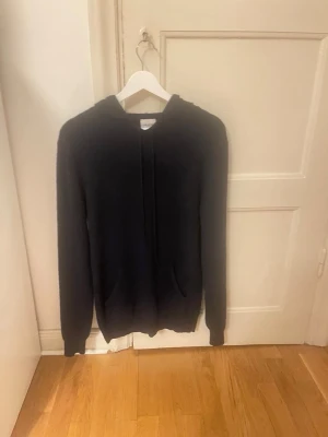 Mörkblå cashmere hoodie John Henric - Mjuk och stilren svart hoodie från John Henric i lyxigt cashmere material. Klassisk modell med huva och dragsnören samt fickor framtill. Perfekt för dig som vill ha en hoodie som känns både exklusiv och bekväm. Hör gärna av dig om funderingar!
