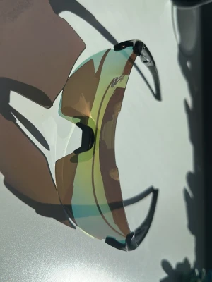 Svarta Bliz Tempo med extra glas - Säljer ett par Bliz Tempo solglasögon med stora, böjda spegelglas i brons/brons. Bågarna är svarta och designen är perfekt för idrottande som löpning eller cykling men funkar även för vardagen. De kommer även med ett hårt fodral som innehåller bland annat extra glas i orange, huvudband och rengöringsduk.
