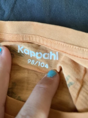 Beige t-shirt med tigermönster Kappahl - Säljer en beige t-shirt från Kappahl med coolt svart tigermönster över hela tröjan. T-shirten har korta ärmar och är gjord i mjuk bomull, perfekt för en avslappnad och lekfull stil.den har lite rosa fläckar!