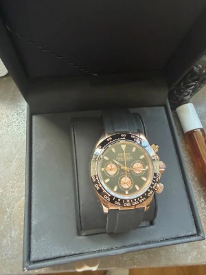Seiko Daytona mod - Stilren Seiko kronografklocka med svart urtavla, guldiga detaljer och svart armband i syntetmaterial. Klockan har tre mindre urtavlor och tydliga indexmarkeringar. Snygg kombination av svart och guld som ger en lyxig känsla. Pris går att diskutera.