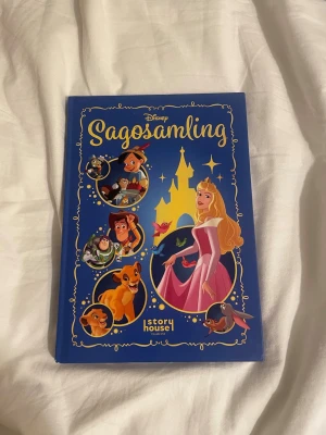 Disney Sagosamling blå bok - En färgglad sagosamling med hård pärm i blått, fylld med klassiska Disney-berättelser som Toy Story 4, Lejonkungen, Törnrosa och Pinocchio. Omslaget har illustrationer av kända Disney-karaktärer och ett slott i bakgrunden. Perfekt för dig som älskar magiska äventyr.