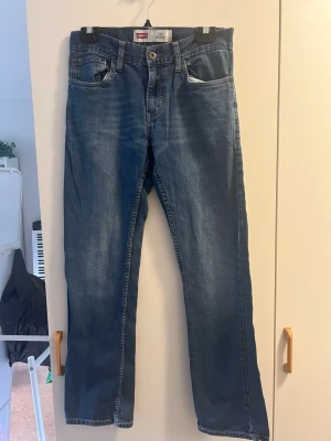 Blå raka jeans från Levi's - Säljer ett par klassiska blå jeans från Levi's med skinny modell. Jeansen har en snygg tvättad look och är tillverkade i slitstarkt denim. W29/L29