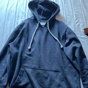 Mörkblå hoodie från Pier One - Snygg mörkblå hoodie från Pier One med klassisk huva och vita snören. Tröjan har en stor magficka framtill och långa ärmar, perfekt för chill dagar. Materialet känns mjukt och bekvämt mot huden. Skriv vid frågor! 