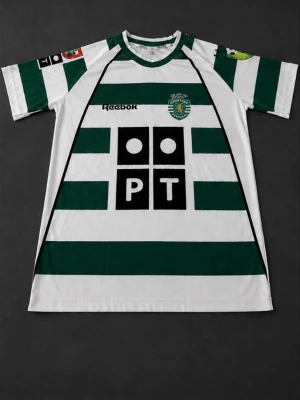 Sporting Lissabon matchtröja Reebok - Grönvit randig matchtröja från Sporting Lissabon med tryck på bröstet och ryggen. Tröjan har korta ärmar, klubbmärke på bröstet och sponsorloggor. På ryggen står det 'C. Ronaldo' och nummer 28. Tillverkad i lätt och ventilerande material.