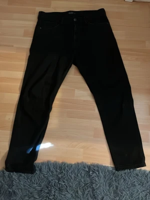 Svarta fit jeans från LCW Jeans - Säljer ett par svarta fit jeans från LCW Jeans i storlek W32. Klassisk femficksmodell med raka ben och bälteshällor. Snygg och enkel design som passar till det mesta. Perfekta för dig som gillar en avslappnad och trendig look.