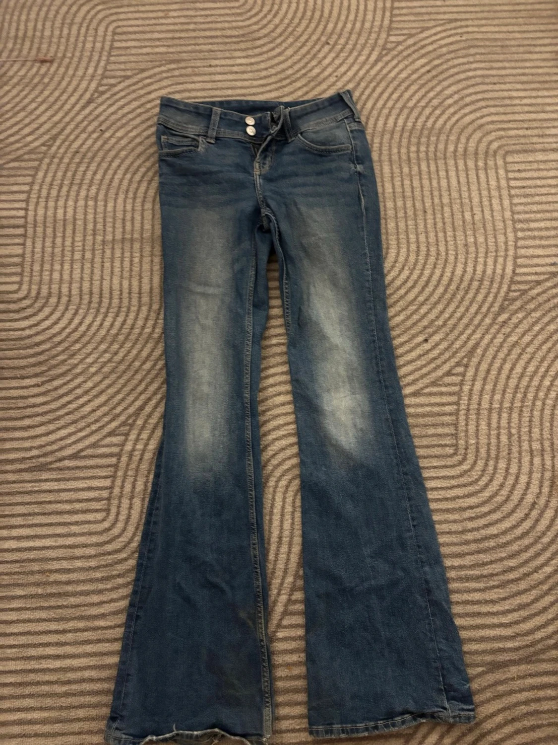 Blå bootcut jeans med slitningar