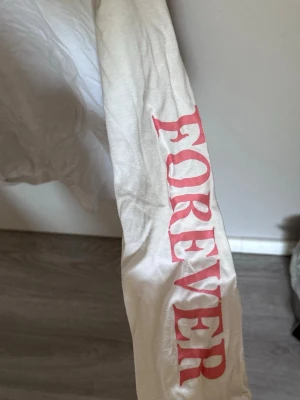 Vit tröja med text på armen  - Fin tröja med rosa text på armen
