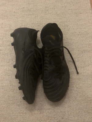 Nike fotbollsskor svarta - Säljer mina svarta Nike fotbollsskor phantom i elit ⚫️ Använda men fortfarande i bra skick, inga hål eller större skador. Dobbarna är hela och skorna är redo för spel direkt. Finns en lite spricka på ena parets undersulla men inget som känns eller syns!  📏 Storlek: 42 ⚽️ AG-dobbar – passar konstgräs  🖤 Svarta Nike 📦 Skickas snabbt  Skriv gärna om du har frågor eller vill ha fler bilder! Endast skorna följer me
