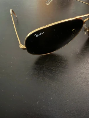 Ray-Ban aviator solglasögon guld - Snygga Ray-Ban aviator solglasögon med tunna guldfärgade metallbågar och svarta glas. Klassisk pilotmodell som ger en cool vibe till vilken outfit som helst. Lätta att bära och passar perfekt till soliga dagar. Inga tecken på användning bara lite damm. Skickar inom 24h! 🚚 📦 
