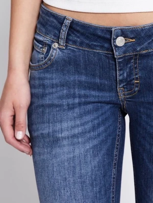 Blå bootcut jeans med låg midja - Säljer ett par blå bootcut jeans med låg midja och klassisk femficksdesign. Jeansen har snygga slitningar och kontrastsömmar som ger en cool vintagekänsla. Tillverkade i stretchigt denim för skön passform.