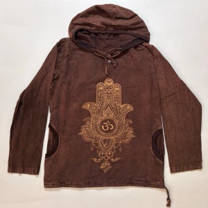 Hamsa Hoodie - Tryck föreställande Om omringad av en lotusblomma och Hamsa symbolen.  100 % bomull behandlat på speciellt sätt vilket ger ett unikt material.  Ny och oanvänd med lapp kvar  Det står inte vilken storlek det är, men ser ut att vara stor M eller liten L  Skicka ett meddelande om du har frågor eller vill se fler bilder