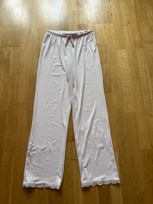 Ljusrosa pyjamasbyxor med spetskant från New yorker❣️ - Mysiga ljusrosa pyjamasbyxor/mjukisbyxor med ränder och söt spetskant längst ner. Byxorna har resår och snören i midjan för extra komfort. Helt nya, oanvända❣️ original pris var 150kr❣️ skriv om ni vill ha fler bilder