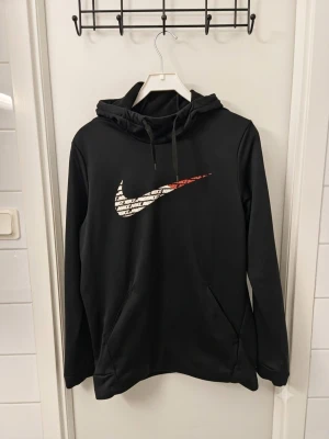 Nike Dri-FIT Hoodie – Svart med Grafik – Stl M 🖤⚡ - Säljer en stilren svart Nike Dri-FIT huvtröja! Har ett snyggt grafiktryckt Swoosh-märke fram, luva med dragsko och en känguruficka. Funktionsmaterialet gör den perfekt för både träning och vardag. I mycket gott skick! Skickas snabbt och spårbart. 📦✨