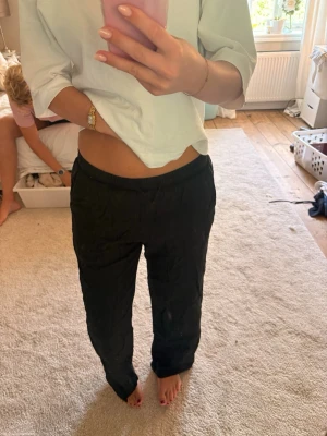 Svarta linnebyxor med resårmidja - Säljer ett par svarta linnebyxor med avslappnad passform och resår i midjan. Byxorna har raka ben och är perfekta för en chill och stilren look. Materialet är luftigt linne som passar bra till sommaren.