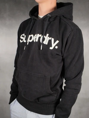 Superdry Hoodie - Superdry Hoodie • Storlek: S • Skick: 8/10 – fint skick utan skavanker • Inkluderas: Endast Hoodie • Nypris: Ca 1200kr • Passform: Modellen på bilden är 180 cm lång, väger 65 kg •