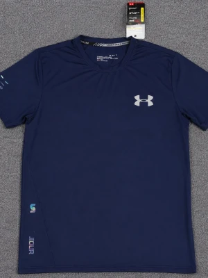 Mörkblå tränings-tshirt Under Armour - Snygg mörkblå tränings-tshirt från Under Armour med rund hals och korta ärmar. Tillverkad i ett lätt och snabbtorkande funktionsmaterial. Logga på bröstet och diskreta tryck på ärm och nederkant. Perfekt för gym eller löpning.