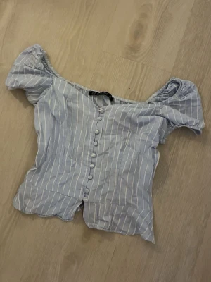 Blåvit randig blus - Söt blåvit randig blus med puffärmar och knappar framtill. har en dragkedja på sidan 