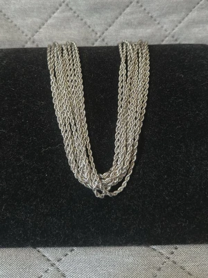  silverfärgat halsband  - Stilrent halsband i silverfärg med tunna, tvinnade kedjor som ger en modern och trendig look. Halsbandet har en elegant design och passar perfekt för att lyfta vilken outfit som helst. Materialet är rostfritt stål. Finns 10st, 80kr st.