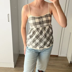 Rutig linnetopp med tunna axelband - Snygg linnetopp med tunna axelband och rutigt mönster i beige och grått. Äääälskar denna topp men kommer tyvärr inte till användning så mycket som den förtjänar