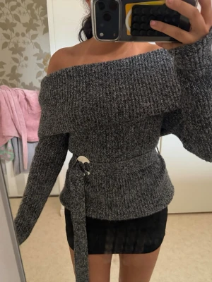 Grå stickad off shoulder tröja - Så snygg off shoulder stickad tröja som man knyter vid midjan med silver detalj. Den är från Zara och är i storlek M men passar mig som bär xs-s då man kan knyta tröjan om man vill att den ska sitta tight eller löst❤️ perfekt till hösten eller vintern som kommer nu. 