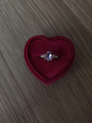 Ring med regnbågsskimrande sten - ring i storlek 17,3mm, guldfärgad.