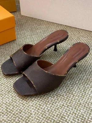 Bruna slip-in pumps med låg klack - Snygga slip-in pumps i mörkbrunt läder med öppen tå och fyrkantig tåform. Skorna har låg smal klack och dekorativ rem i ljusbrunt med guldfärgad detalj. Märkta som 40 men passar mer som en storlek 39