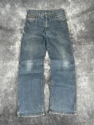Blå raka jeans med slitningar - Mörkblå Wrangler Texas-jeans för herrar i storlek W31 L34. Klassisk rak Texas-passform, snygg tvätt och denim av hög kvalitet.  Skick: 9,5/10  Midja: 31 cm Lår: 30 cm Benslut: 20 cm Totallängd: 104 cm Måtten finns även på bilderna  Skickas inom ett dygn På min profil finns fler Wrangler-jeans C49