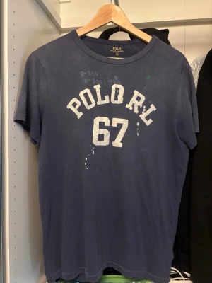 Ralph lauren t-shirt - Polo Ralph lauren t shirt som står polo rl 67. Size M bra skick. Har två Micro hål typ mitten på tröjan men är så små så knapps syns