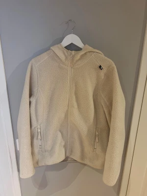 Beige teddyjacka med luva i storlek  xl men är liten i storleken.  - Mysig beige teddyjacka med dragkedja framtill, två fickor med dragkedja och luva. Tillverkad i fluffigt teddy-material som ger en avslappnad och trendig look.  Jag brukar ha m/l på tröjor o jackor men xl på denna så den är väldigt liten i storleken.