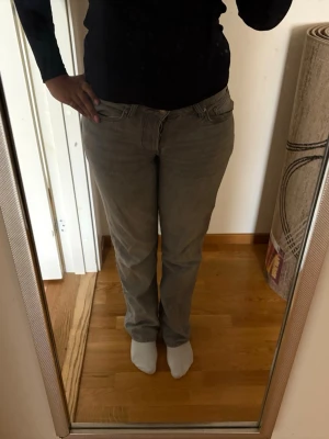 Gråa raka jeans - Säljer ett par gråa jeans med rak passform och klassisk femficksdesign. Jeansen har normal midja och stängs med dragkedja och knapp. Perfekta för dig som gillar en enkel och stilren look.