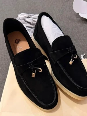  Loro piana Svarta mockaloafers med dekor - Stilrena svarta loafers i mocka med dekorativ metall-detalj framtill och vit sula. Klassisk form med rundad tå och diskret söm längs kanten. Perfekta för dig som gillar en clean och modern look.