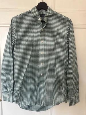 Grönvitrutig skjorta Polo Ralph Lauren - Snygg grön och vit rutig skjorta från Polo Ralph Lauren. Klassisk krage, knäppning framtill och långa ärmar. Tillverkad i mjuk bomull som känns skön mot huden. Perfekt för dig som gillar en tidlös och fräsch stil.