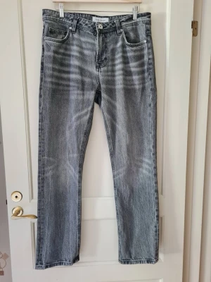Grå jeans från SMOG (New Yorker) strl 31/32 - Säljer ett par grå jeans från SMOG / New Yorker. Jeansen har klassiska fem fickor, bälteshällor och knappgylf. Material 100% bomull. Storlek 31/32.