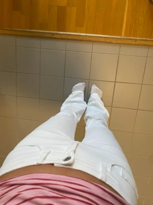 Vita bootcut jeans med fickor lågmidjade  - Säljer ett par vita bootcut jeans med klassiska fem fickor och bälteshällor. Jeansen har en snygg passform och är tillverkade i ett stretchigt denimtyg som sitter bekvämt. Perfekta för dig som vill ha en clean och fräsch look.