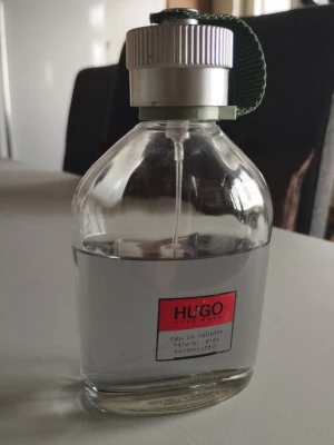 Hugo by Hugo Boss Edt herrparfym - Klassisk herrparfym från Hugo Boss i en genomskinlig glasflaska med silverfärgad kork och grön tygrem. Maskulin men fräsh. Flaskan rymmer 150ml och vi gissar att ca 100ml är kvar i. Ps. Kolla gärna mina andra annonser