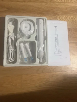 Ultraljudstandborste med tillbehör - Säljer en vit ultraljudstandborste med flera borsthuvuden, laddare och sladd. Allt ligger i originalförpackning och en manual medföljer. Perfekt för dig som vill ha en effektiv och modern tandborste.