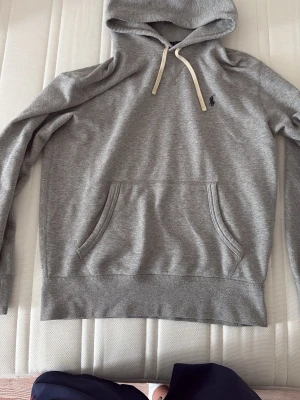 Ralph lauren hoodie - Grå Ralph lauren hoodie med huva och vita snören. Tillverkad i mjukt bomull. Storlek S!