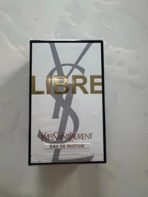 Yves Saint Laurent Libre EdP 90ml - Yves Saint Laurent Libre Eau de Parfum i 30 ml flaska. Snygg vit och svart förpackning med guldtext och YSL-logga. En lyxig parfym som kombinerar elegans och modern stil, perfekt för dig som vill sticka ut.